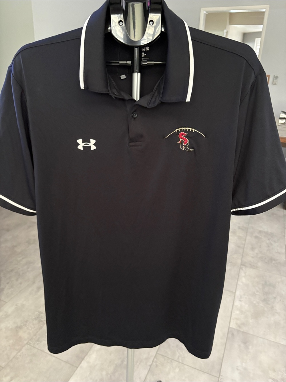 Under Armour Men’s Black Performance Polo with White Trim and Red Logo.